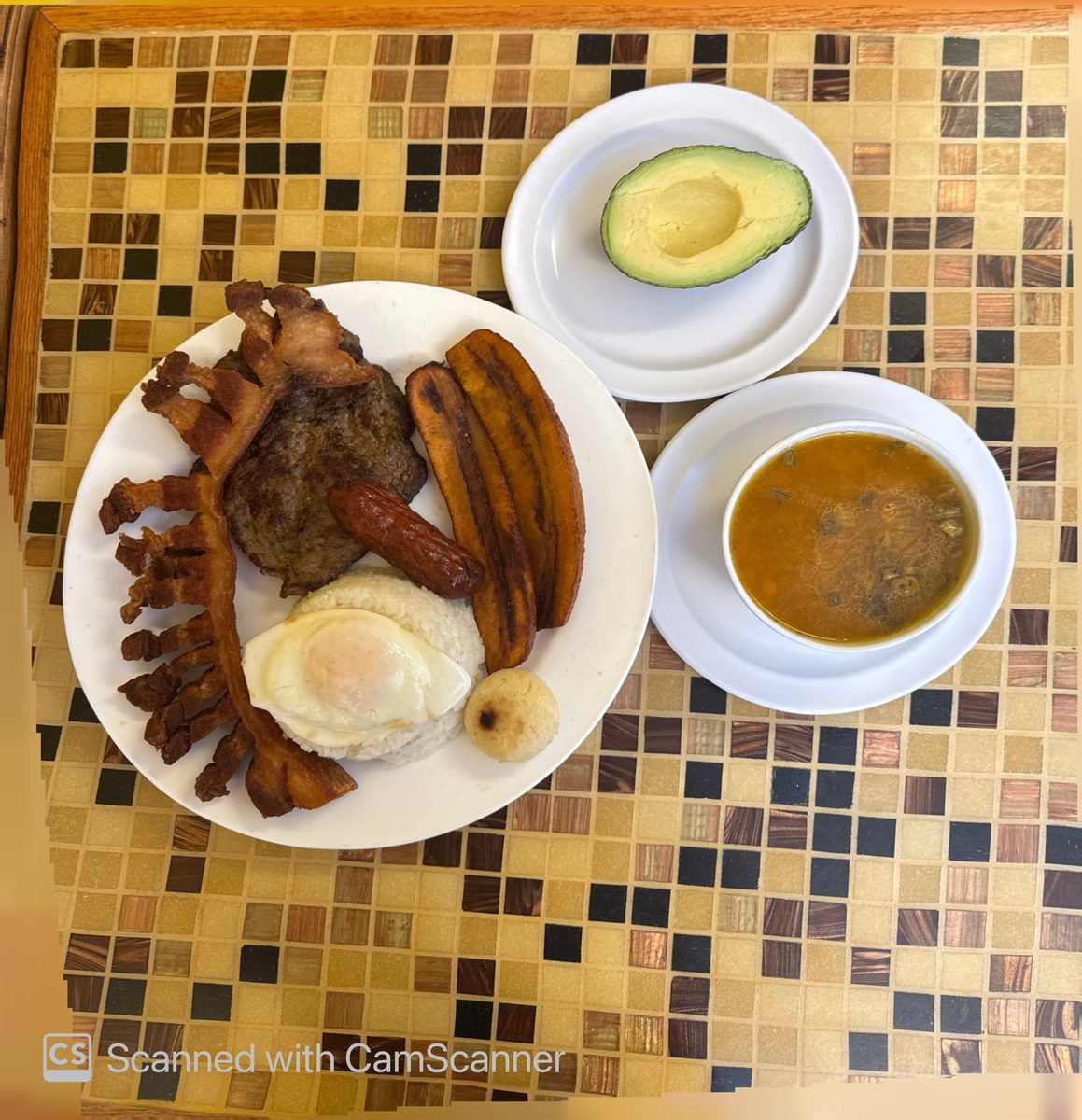 Bandeja paisa con carne, chicharrón, chorizo, huevo, plátano, arepa y aguacate